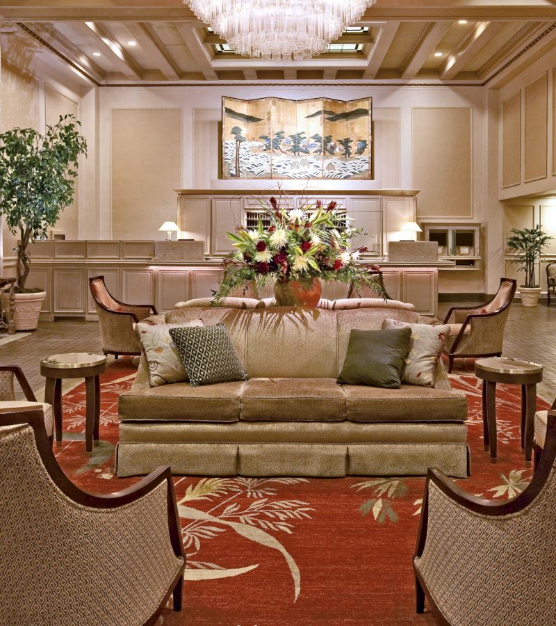 A luxurious lobby with a large sofa, chairs, and a coffee table