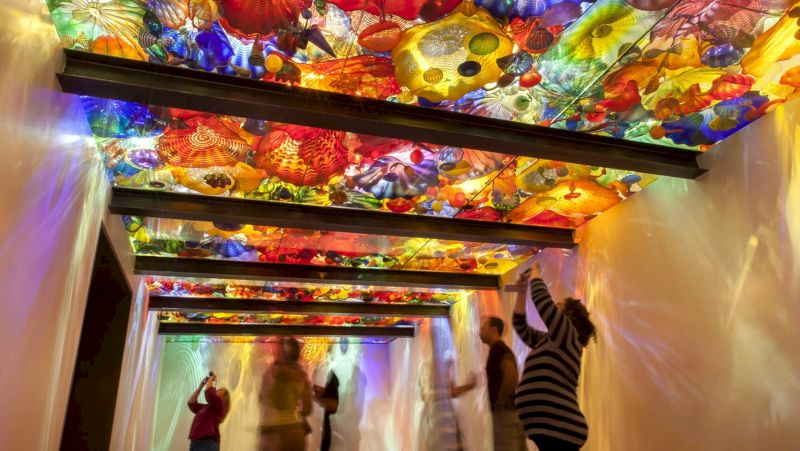 a colorful glass installation on the ceiling of a hallway