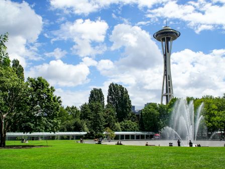 A sunny afternoon at Seattle Center featuring the International Fountain and the Space Needle towering in the background, just minutes from our hotel near Seattle Center.